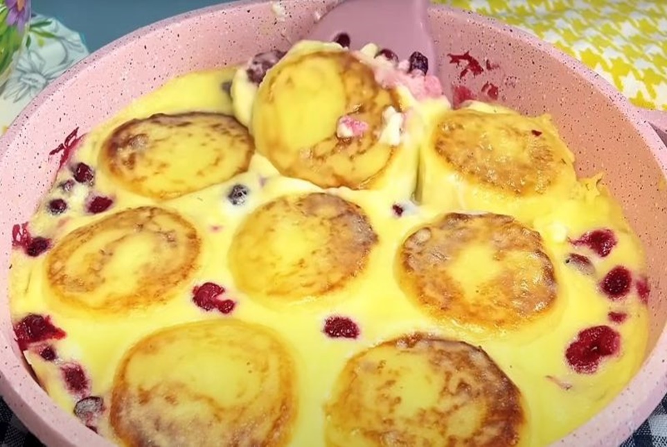 Un alfel de papanasi care sunt coapti în cuptor, sub un strat delicat de smântână și care face textura preparatului catifelată